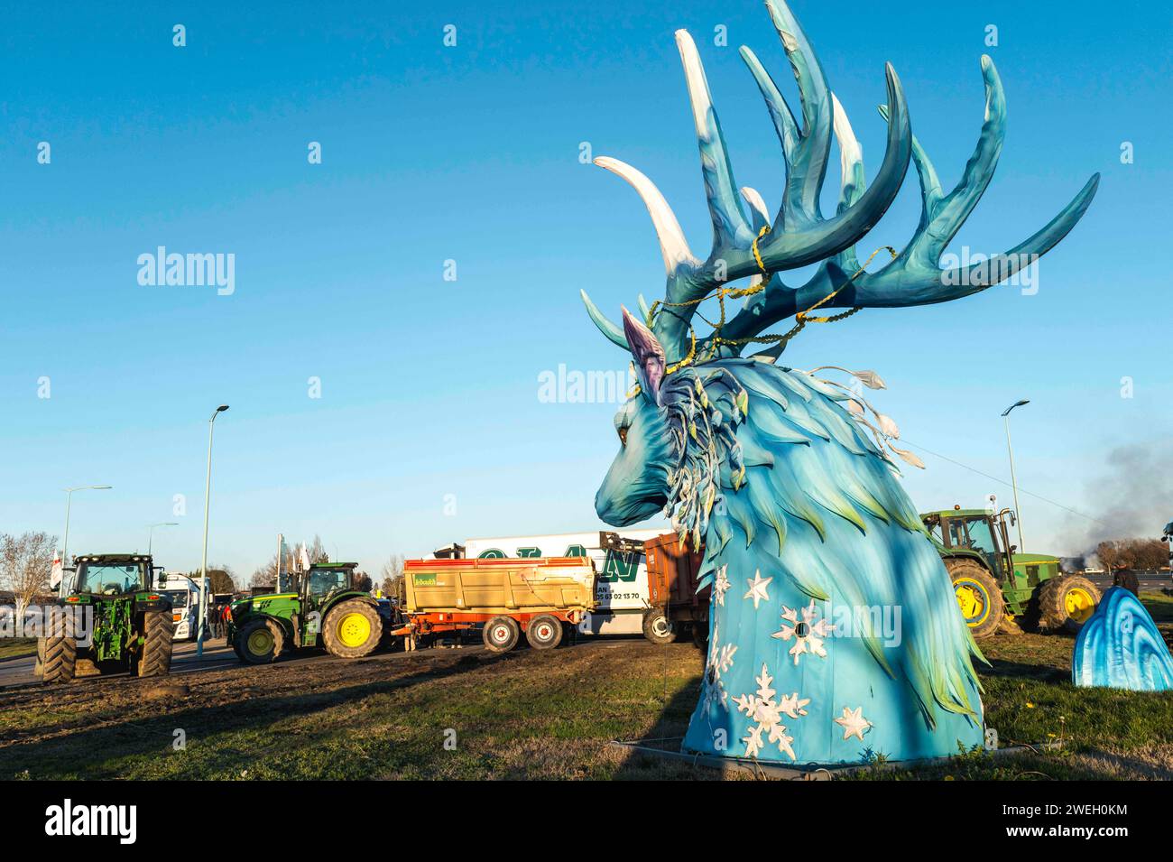 Montauban, France. 25 janvier 2024. Au premier plan un cerf du Festival des lanternes. Contrôle des camions transportant des marchandises, contrôle des papiers et de l'origine des produits transportés par les camionneurs, au rond-point Aussonne à Montauban, France, le 25 janvier 2024. Produits confisqués redistribués aux restos du coeur. Les agriculteurs FNSEA et JA du Tarn-et-Garonne organisent un rassemblement et un blocus. Photo de Patricia Huchot-Boissier/ABACAPRESS.COM crédit : Abaca Press/Alamy Live News Banque D'Images