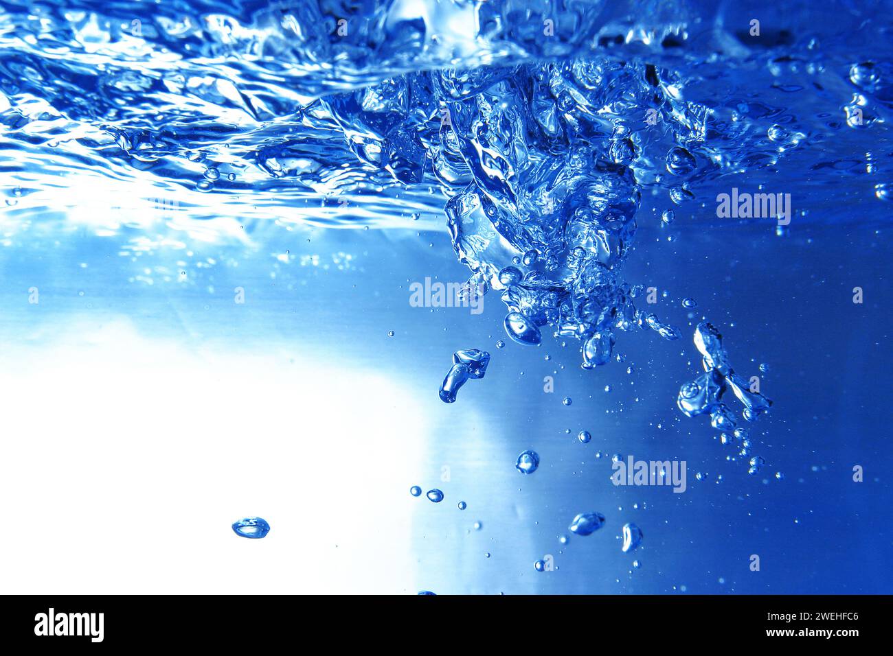 beaucoup de bulles d'air bleues sous la surface de l'eau dans l'aquarium, eau moussante, gros plan Banque D'Images