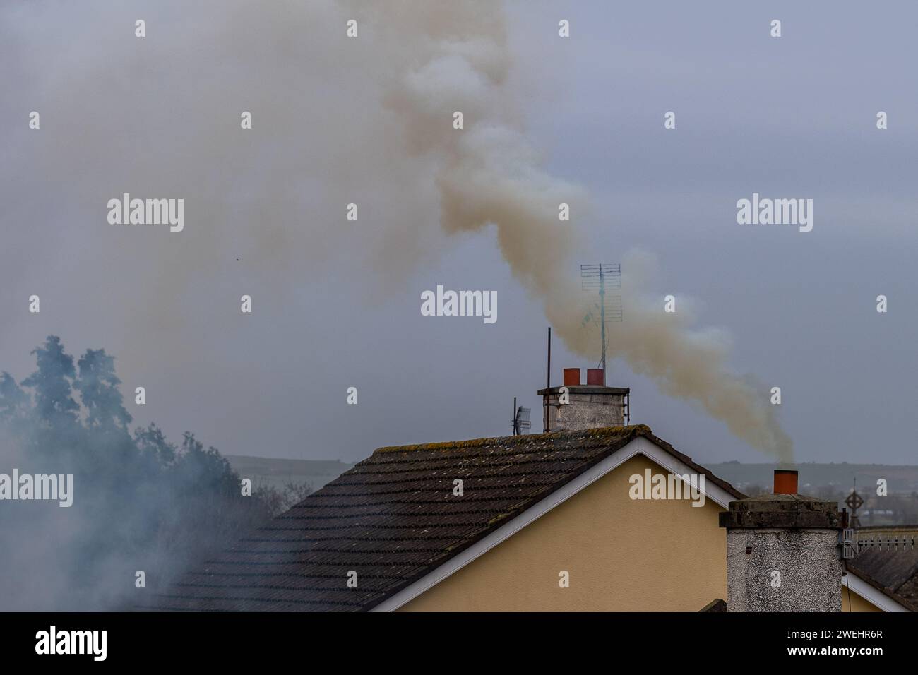 Fumée s'élevant d'une cheminée de maison en Irlande Banque D'Images