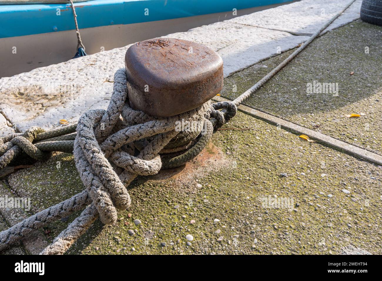 Gros plan d'un nœud fait avec une corde de bateau de pêche amarrée à une cheville de fer dans un port de Grado, Italie. Articles pour bateaux de pêche. Articles marins. Banque D'Images