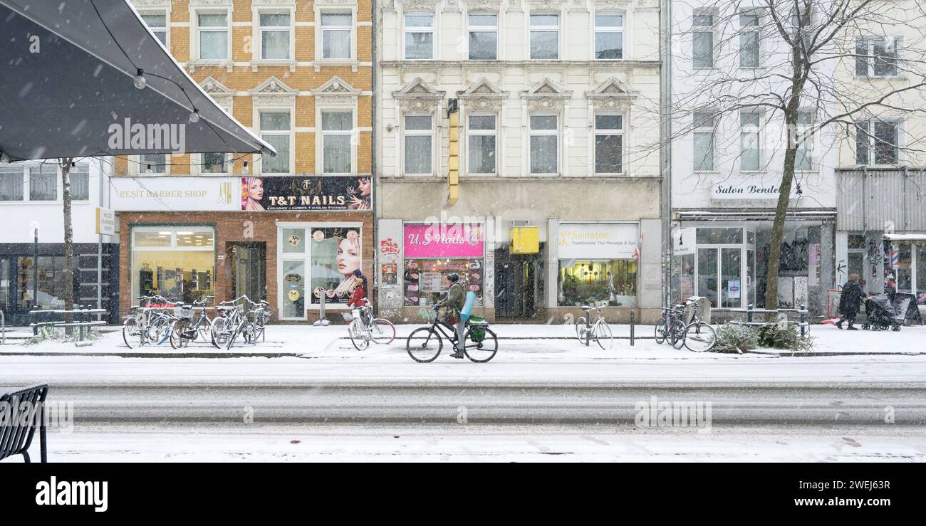 Cologne, Allemagne janvier 17 2024 : un cycliste roule dans les chutes de neige sur venloer strasse à cologne ehrenfeld Banque D'Images