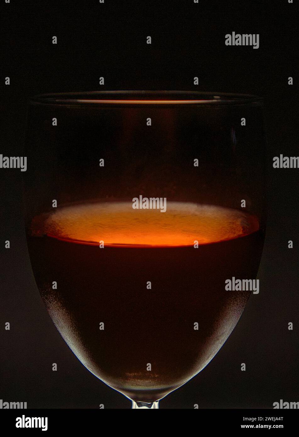 Un verre à vin est éclairé par une lumière LED colorée. Banque D'Images