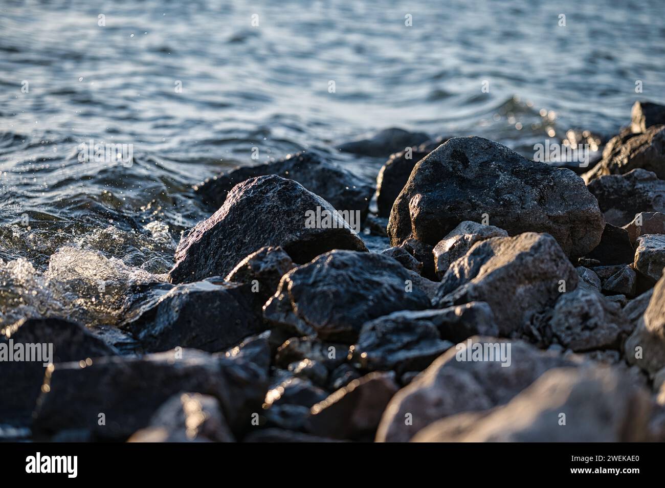 L'eau éclabousse sur les rochers au milieu du vaste océan Banque D'Images