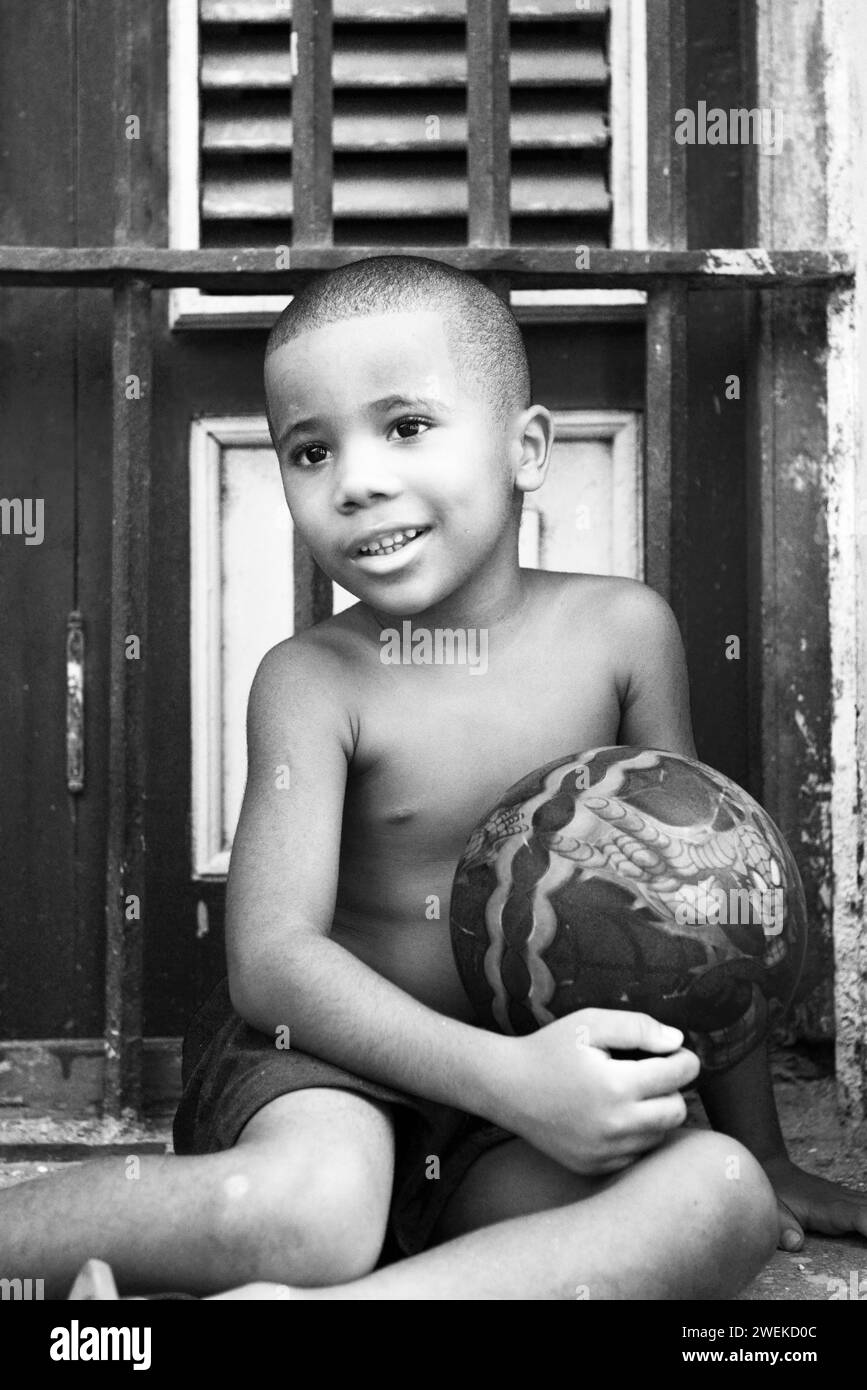 Un garçon cubain tenant son ballon de football. Vieille Havane, Cuba. Banque D'Images