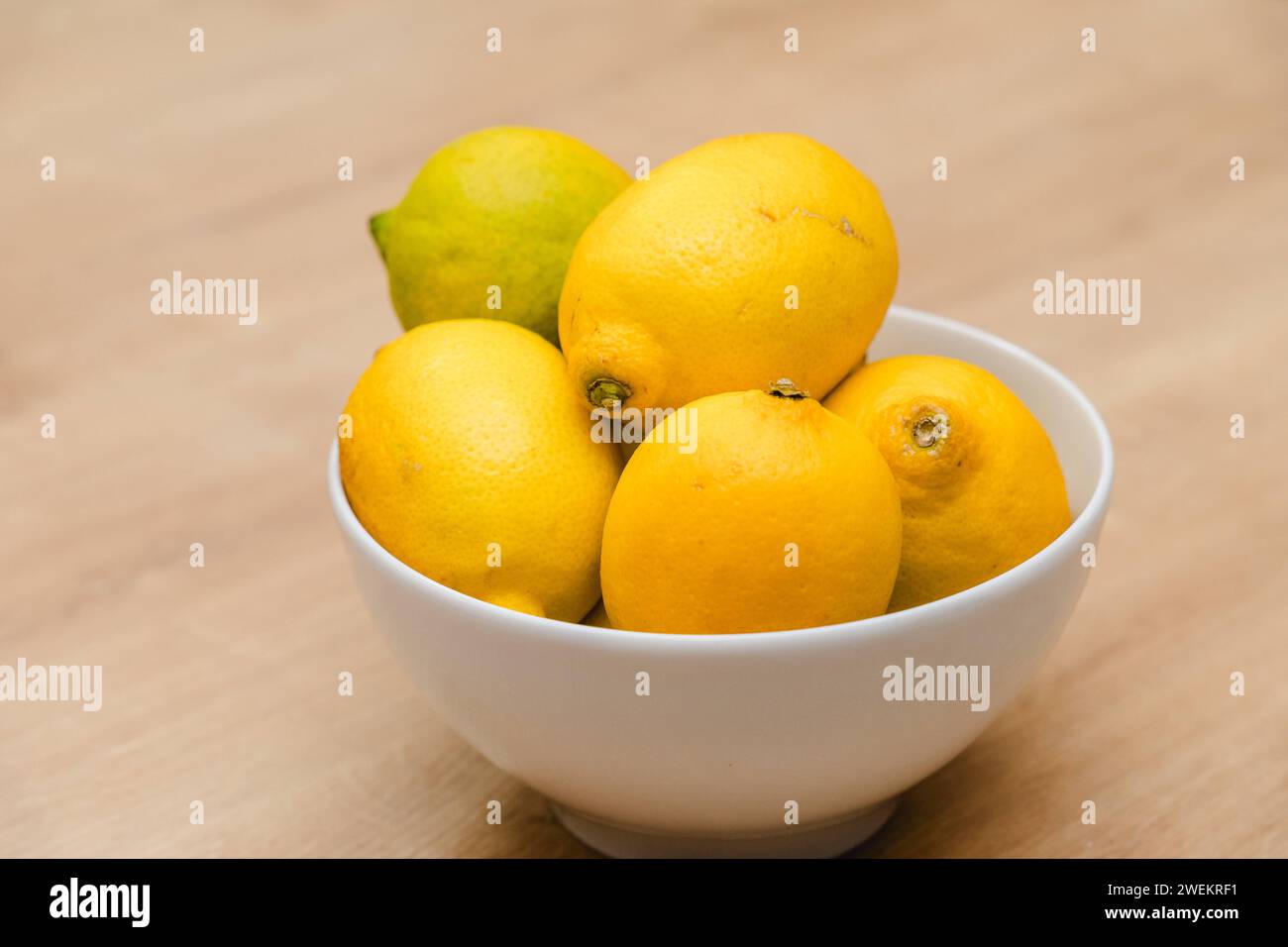 Bavière, Allemagne - 25 janvier 2024 : citrons jaunes dans un bol blanc sur une table *** gelbe Zitronen in einer weißem Schale auf einem Tisch Banque D'Images
