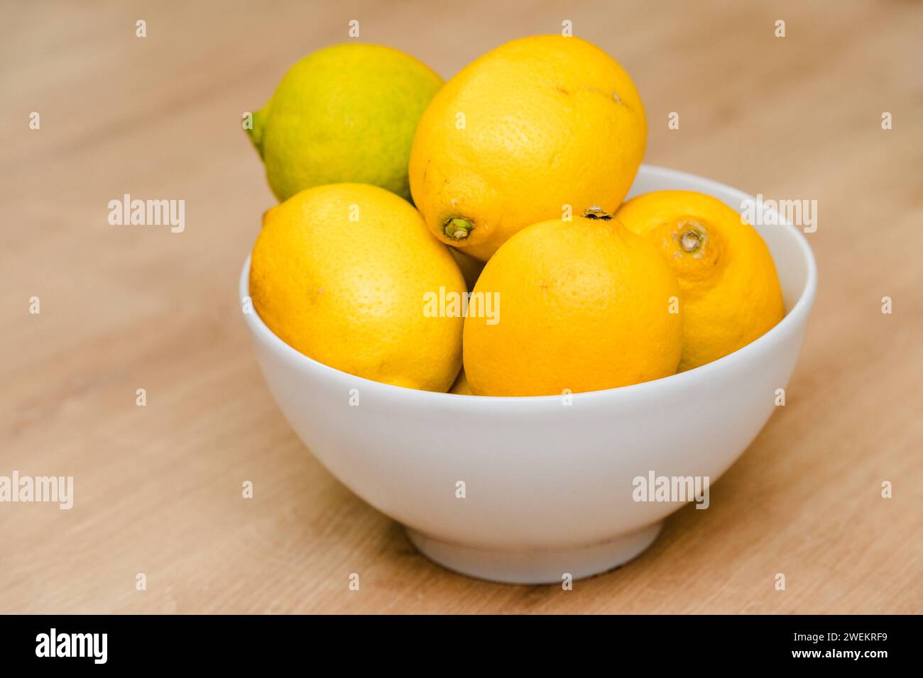 Bavière, Allemagne - 25 janvier 2024 : citrons jaunes dans un bol blanc sur une table *** gelbe Zitronen in einer weißem Schale auf einem Tisch Banque D'Images