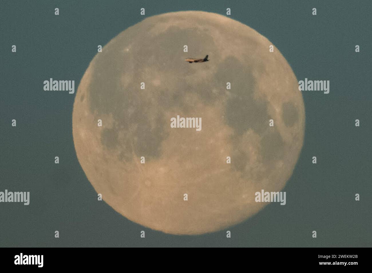 Londres, Royaume-Uni. 26 janvier 2024. UK Météo : Full Wolf Moon voit un jet de passagers traverser alors qu'il se couche au-dessus de la ville dans la lumière du lever du soleil du matin. Crédit : Guy Corbishley/Alamy Live News Banque D'Images