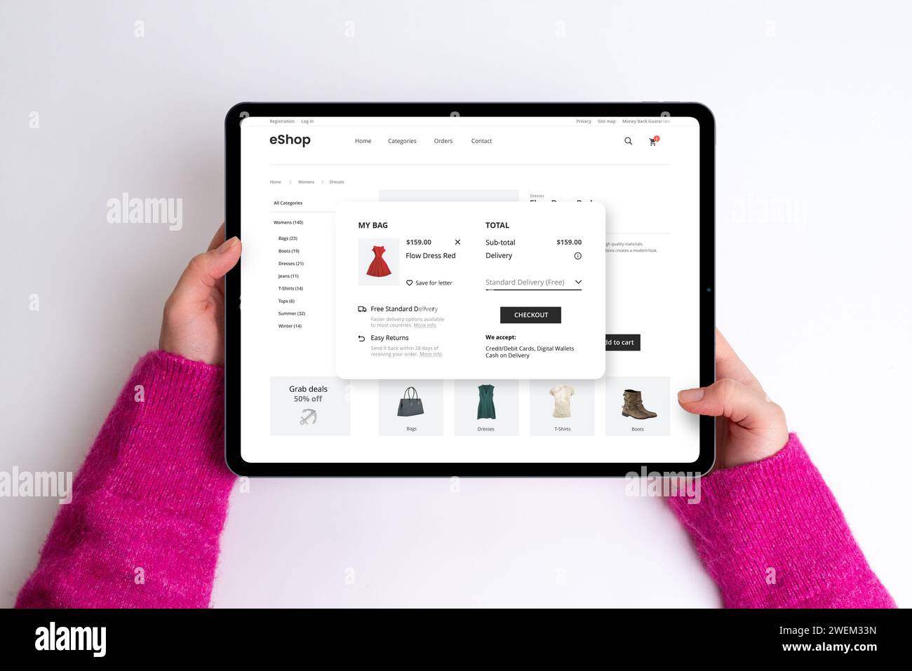 Page de panier e-commerce sur une tablette avec prix, options de livraison et bouton de paiement. Femme achète une robe rouge, créant un sho en ligne sans couture et élégant Banque D'Images