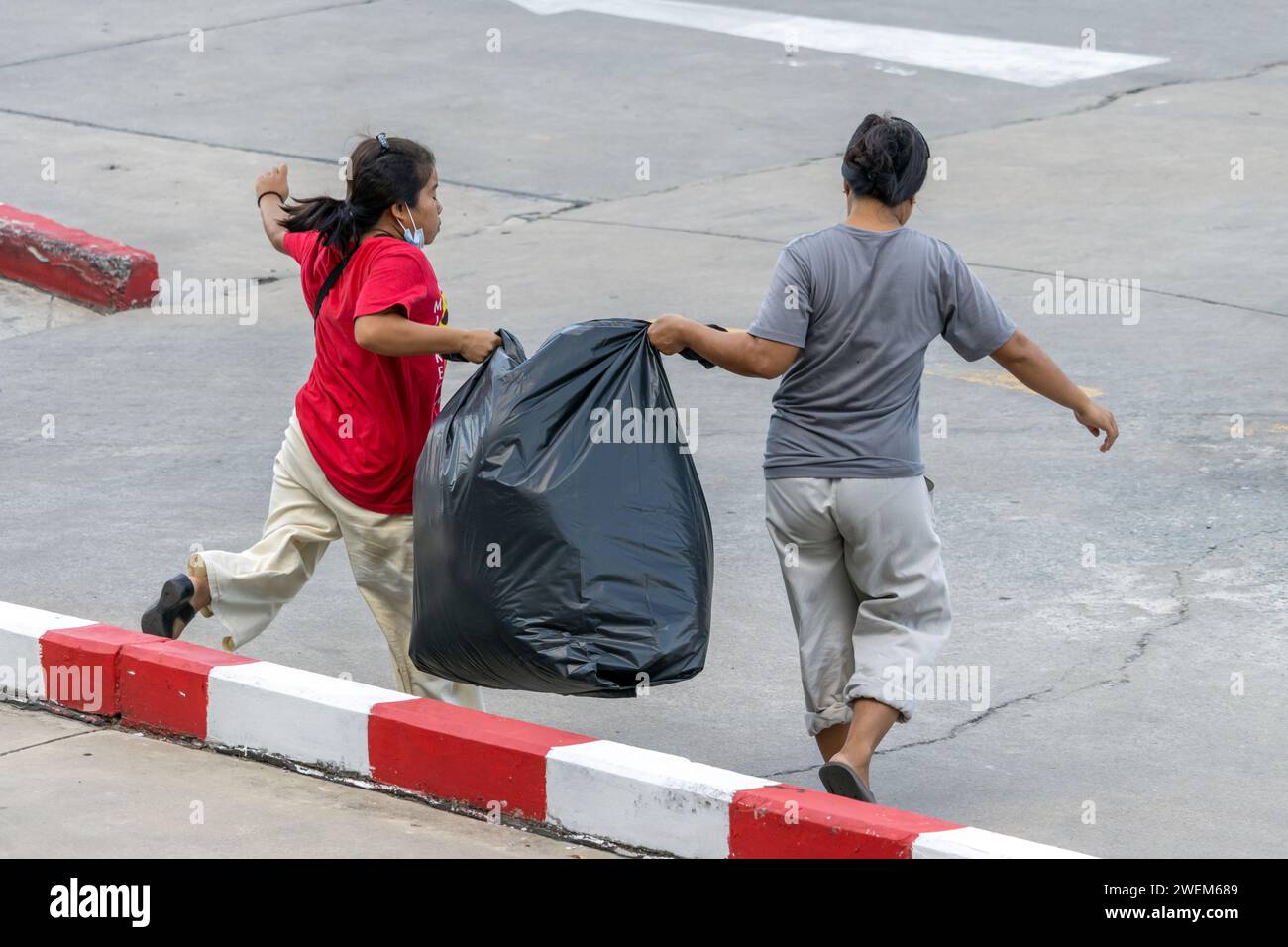 SAMUT PRAKAN, THAÏLANDE, décembre 07 2023, Une paire de femmes portent un gros sac de déchets Banque D'Images
