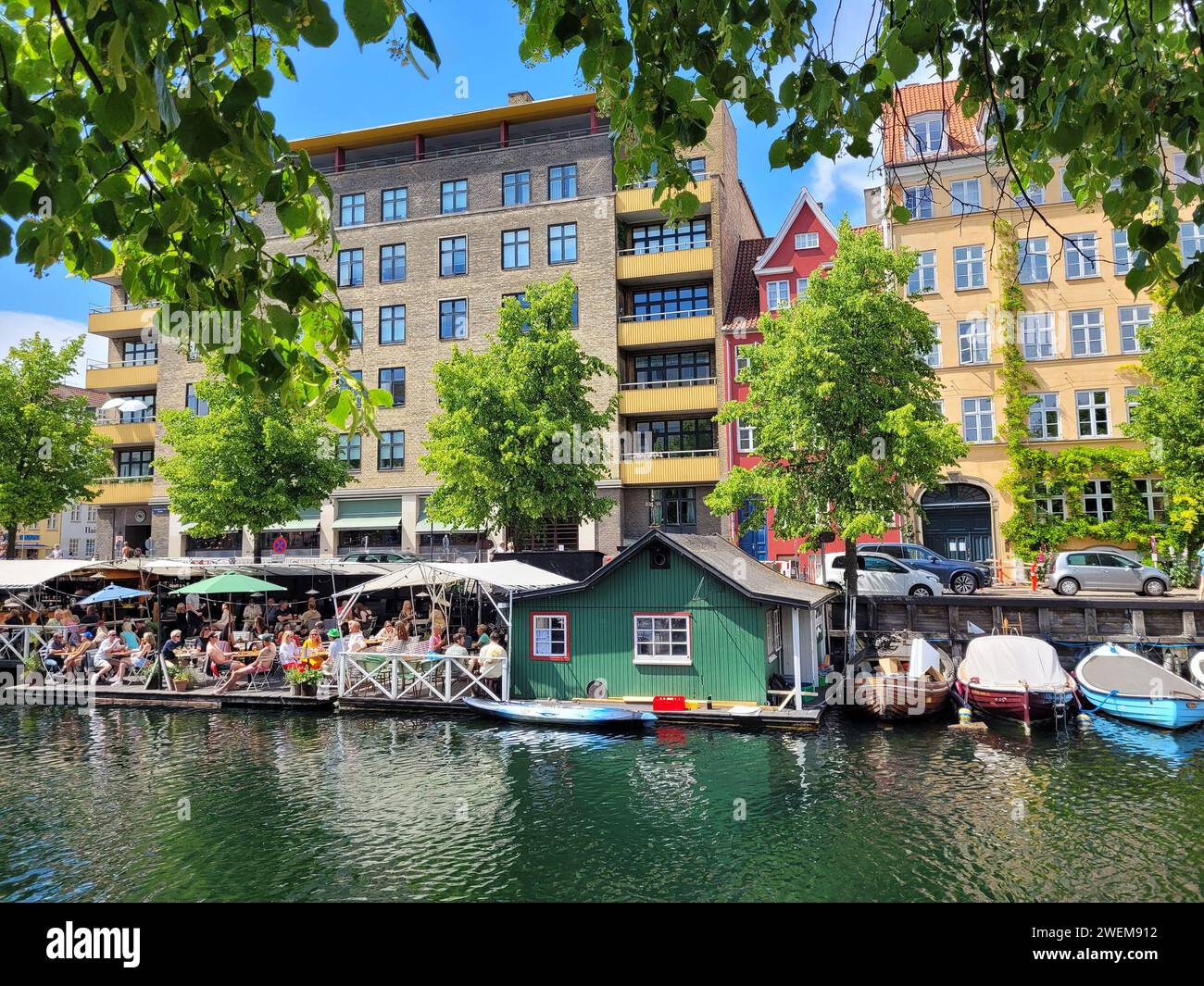 Les gens déjeunent sur une terrasse de restaurant au bord de l'eau dans Christianshavn Canal, Copenhague, Danemark Banque D'Images
