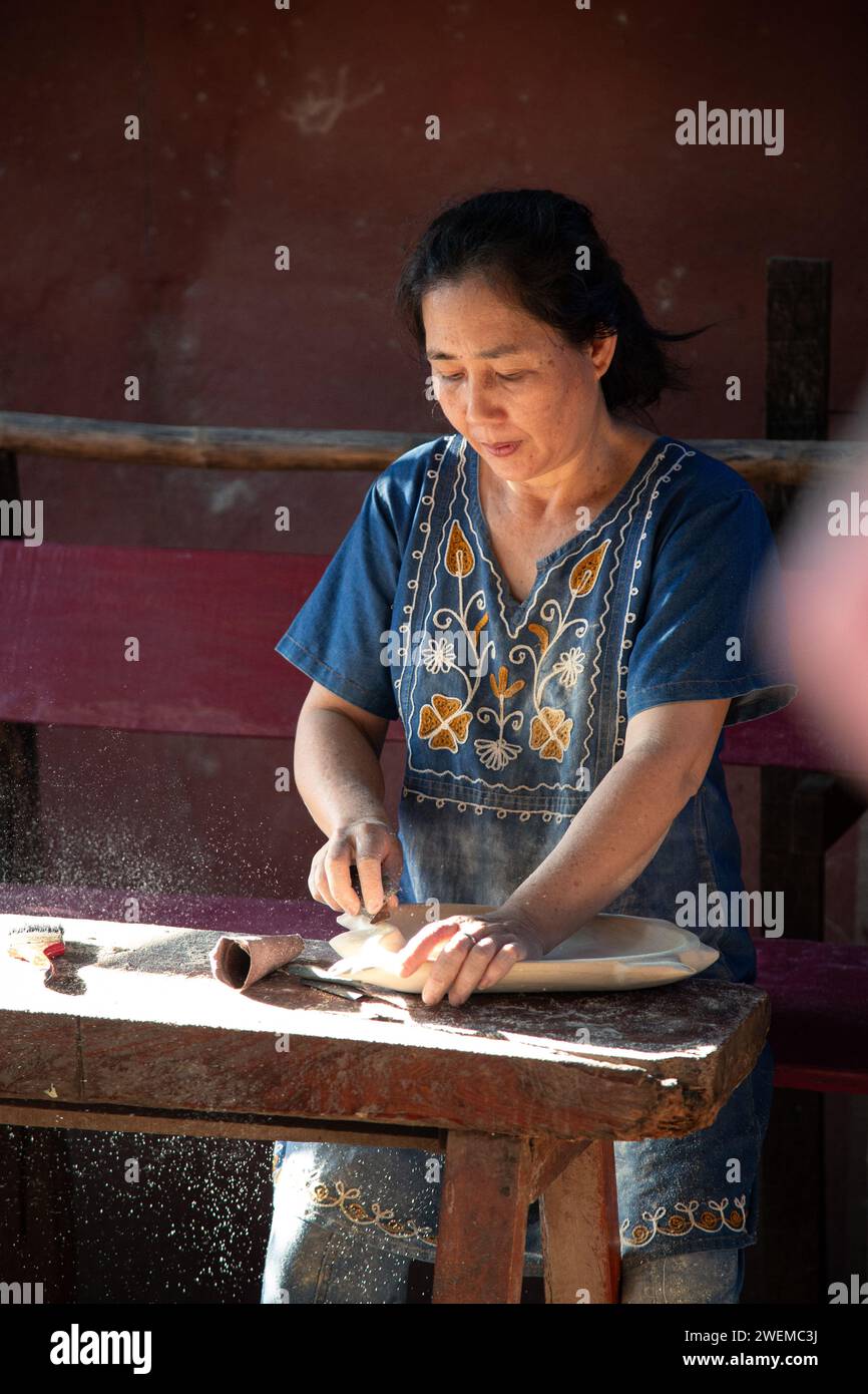 Femme laotienne créant une plaque en bois Banque D'Images