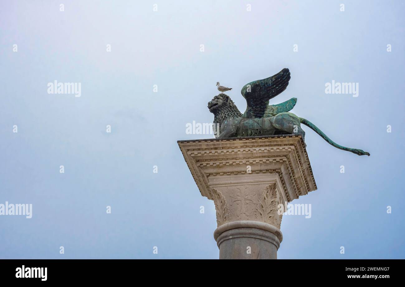 Lion ailé de Saint-Marc, ancienne statue de bronze sur une colonne de la place Saint-Marc, célèbre attraction touristique de Venise. Italie Banque D'Images