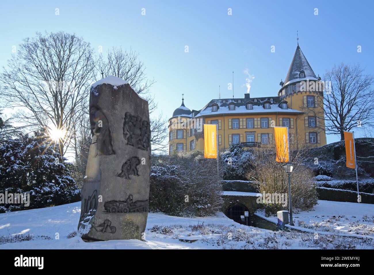 Château Genoveva construit 13e siècle rétro-éclairé en hiver avec support de pierre de sculpture, tailleur de pierre, pierre, rayons de soleil, drapeaux Eifelmuseum, point de repère, neige Banque D'Images