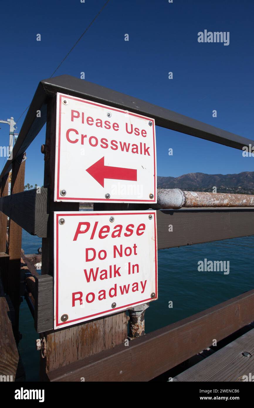 des panneaux d'utilité publique avertissent les piétons d'utiliser le passage pour piétons et de ne pas marcher sur la route Banque D'Images