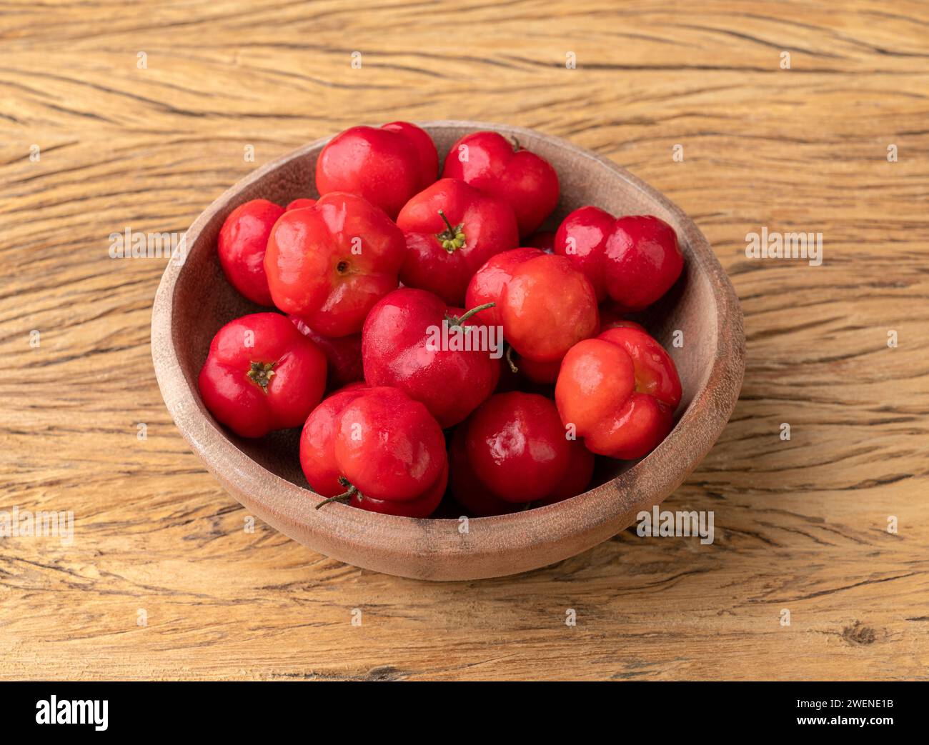 Acerolas ou la Barbade Cherries dans un bol sur une table en bois. Banque D'Images