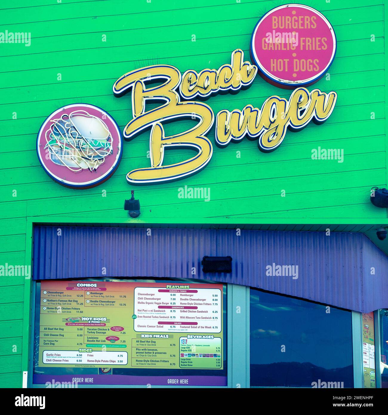 L'extérieur du restaurant Brach Burger sur la jetée de Santa Monica montrant le panneau et le menu de l'établissement, texte jaune contre un mur vert. Banque D'Images