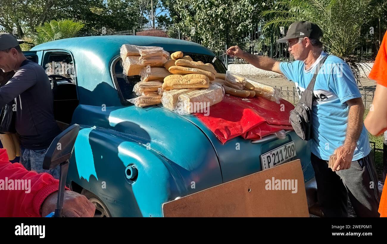 Homme cubain vendant des pains dans une voiture vintage à Santa Clara, Cuba Banque D'Images