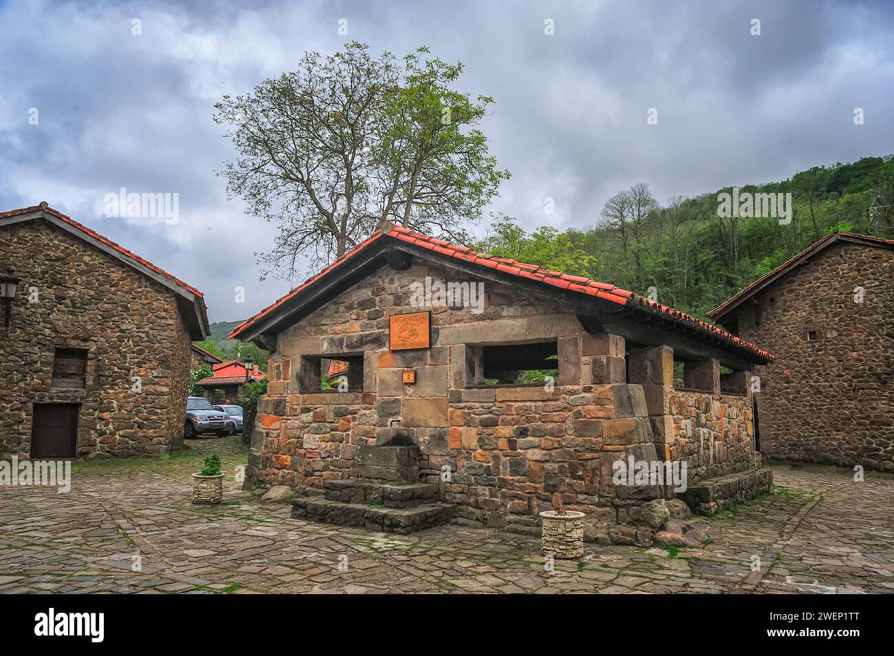 Un lavoir traditionnel bien conservé au cœur d'un village espagnol, entouré de rues pavées et de vieux bâtiments en pierre Banque D'Images