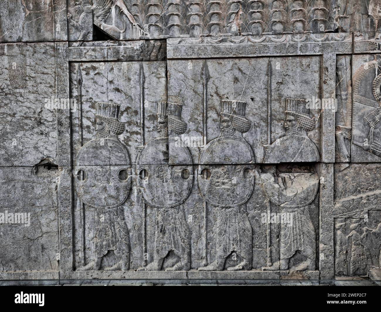 Guerriers perses portant boucliers et lances, bas-relief à Persépolis, capitale cérémonielle de l'Empire achéménide (550–330 av. J.-C.). Province de Fars, Iran. Banque D'Images