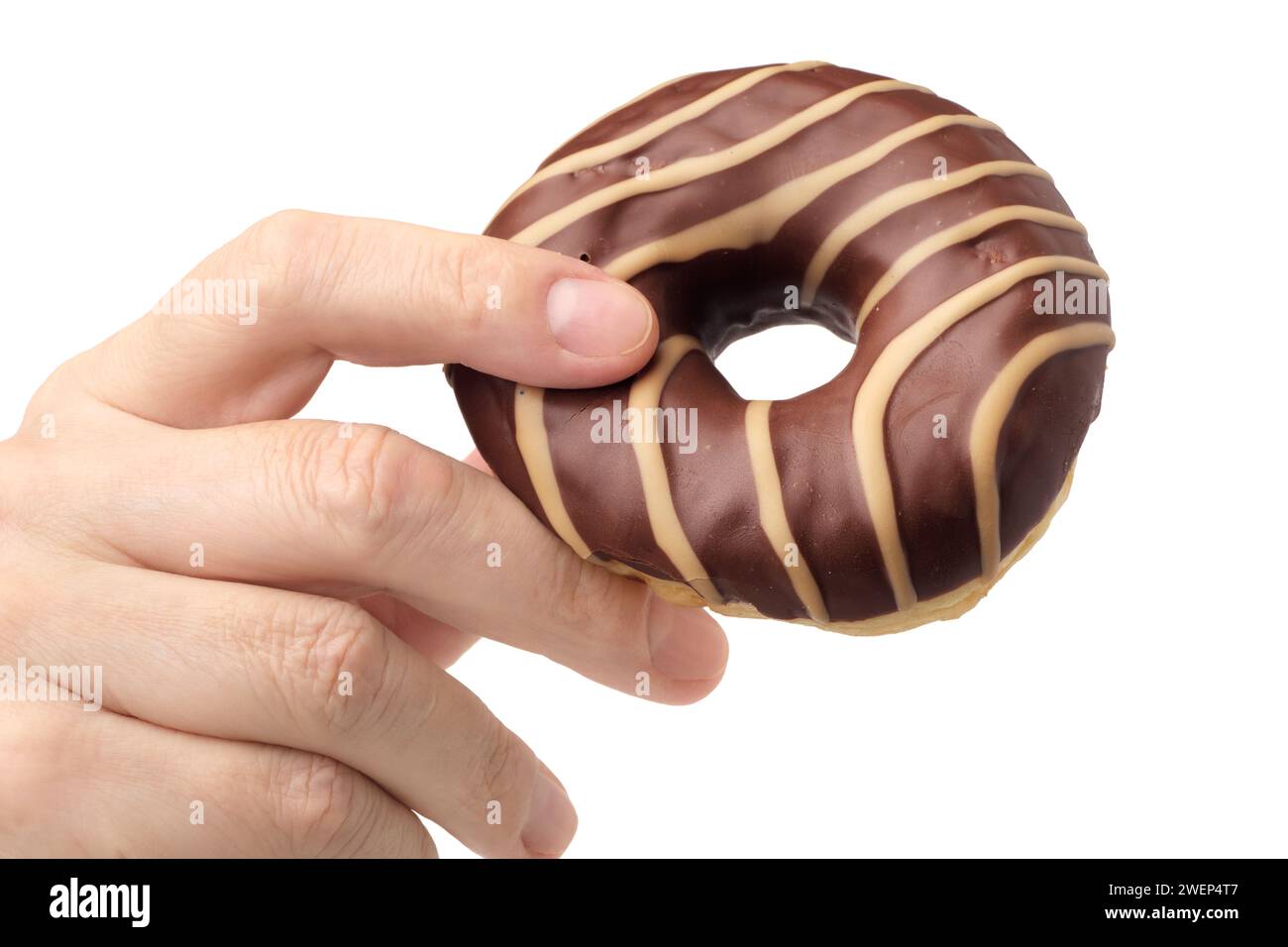 Main humaine tenant le chocolat rayé et le beignet caramel, isolé sur fond blanc Banque D'Images