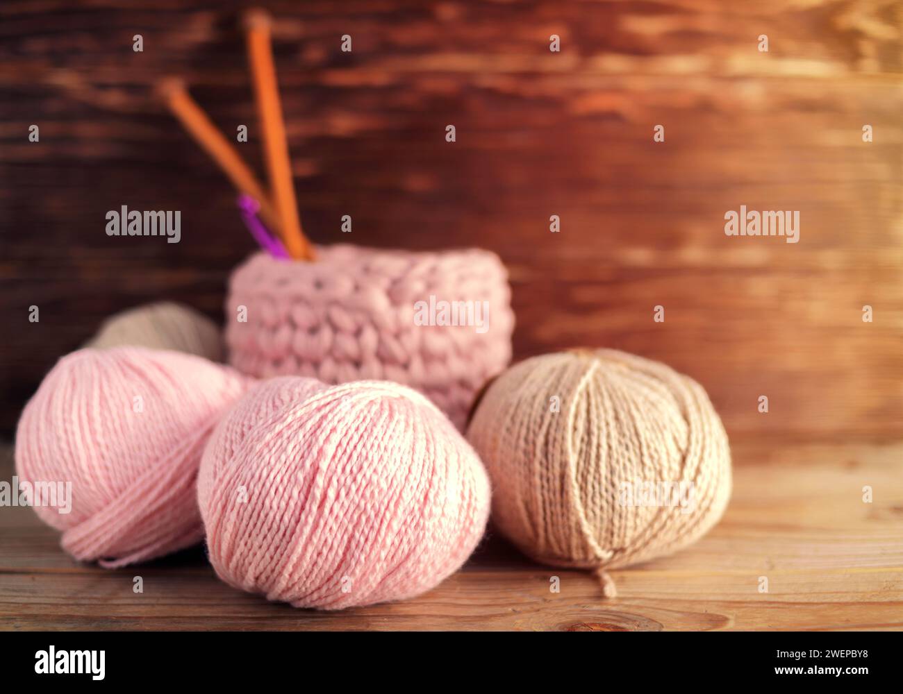 Boules de fil de laine et aiguilles à tricoter en bois sur un fond en bois.nitting. Seau avec accessoires de tricotage. Banque D'Images