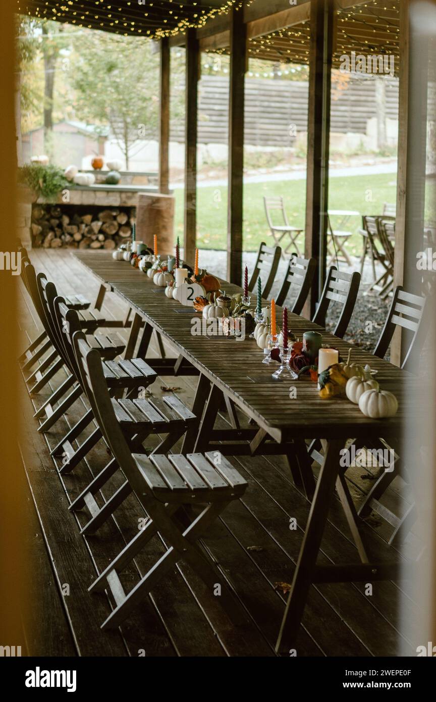 Rangées de tables en bois avec des chaises disposées soigneusement sur une terrasse dans une configuration de banquet d'automne Banque D'Images