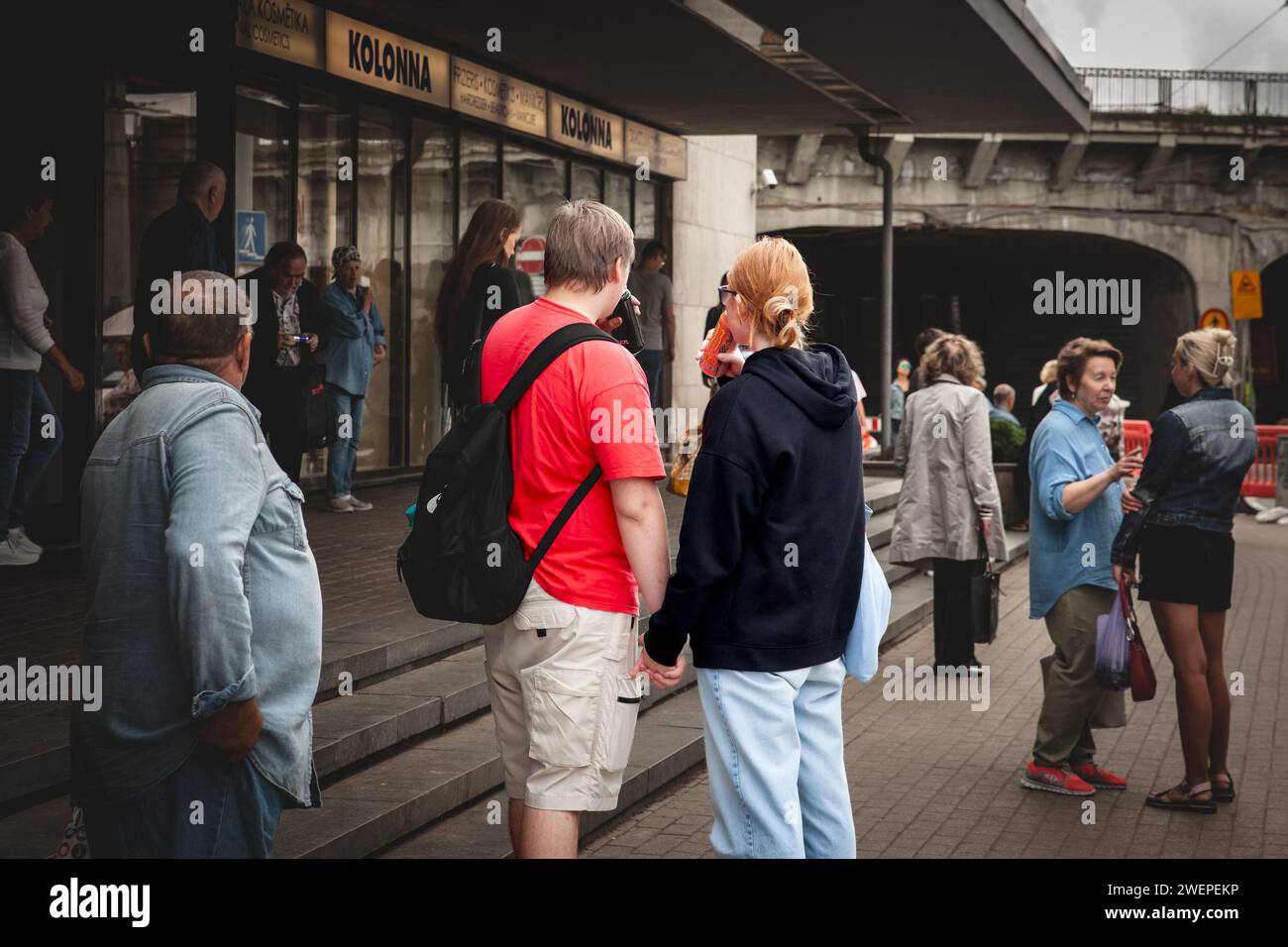 Photo d'un couple de lettons buvant une boisson énergétique dans des canettes dans le centre-ville de Riga. Banque D'Images