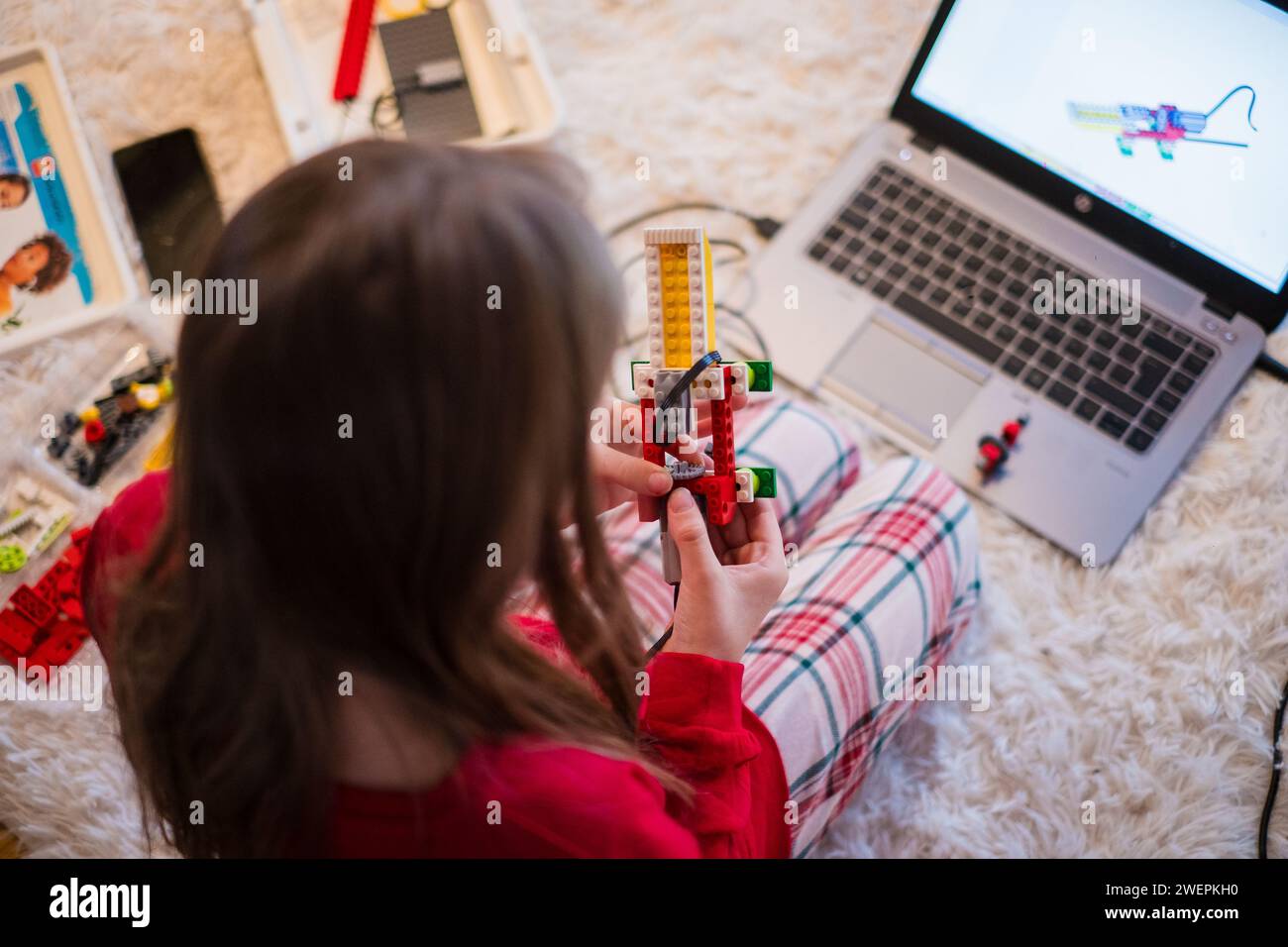 Tallinn, Estonie - 25 décembre 2023 : enfant construisant un robot Lego Education WEDO en mouvement à la maison. Banque D'Images