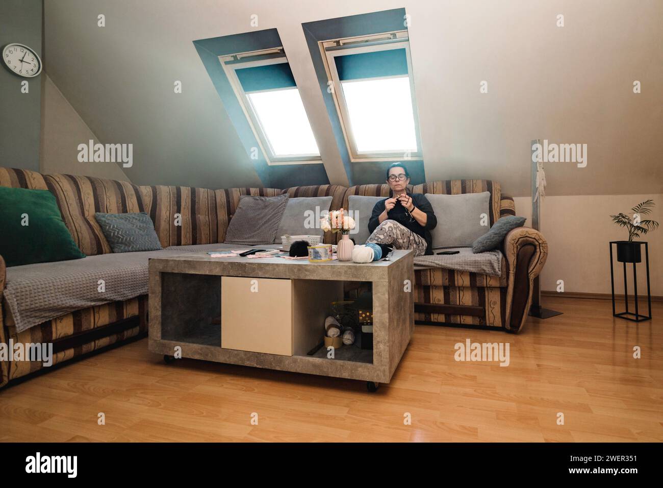 Une femme âgée assise dans son salon et tricotant avec de la laine Banque D'Images