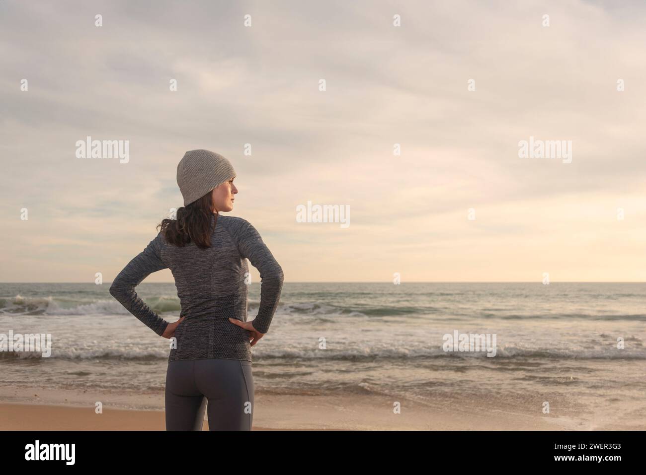 coureur femme sportive, se reposant et regardant la mer après avoir couru à la plage Banque D'Images