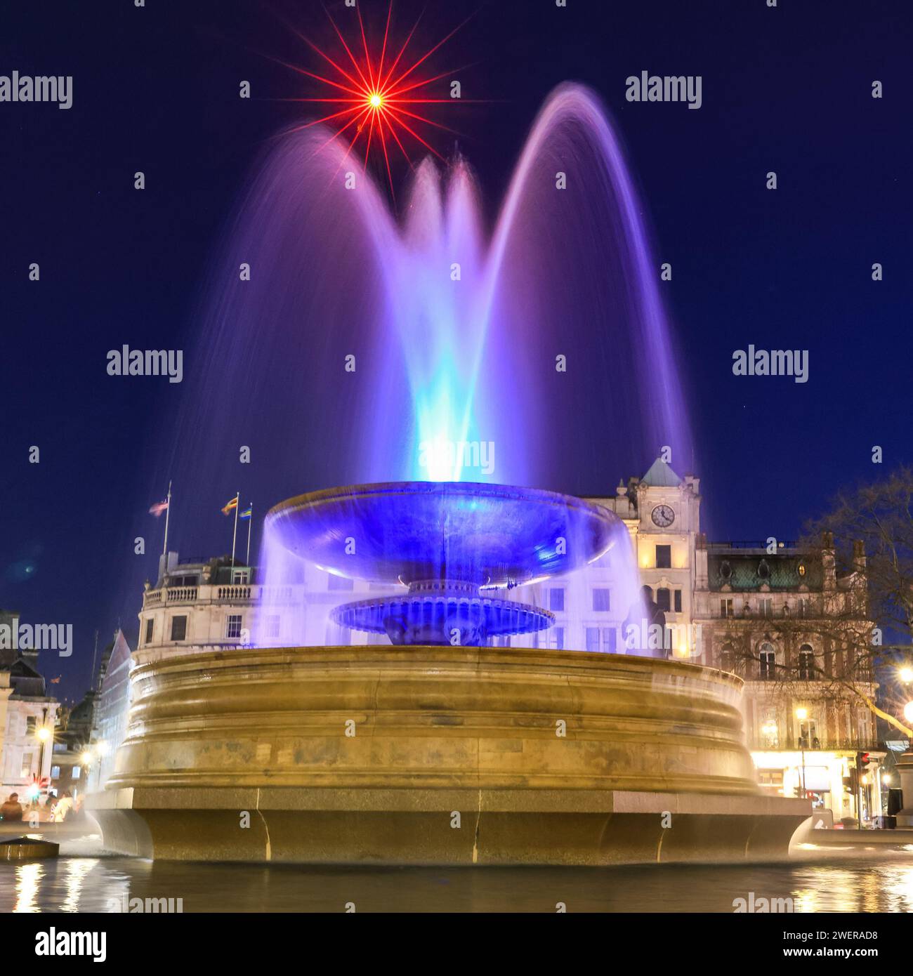 Londres, Royaume-Uni. 26 janvier 2024. Les fontaines illuminées sur Trafalgar Square sont jolies dans le ciel bleu clair du soir, avec une lumière rouge sur une grue de construction ajoutant une touche de couleur. Après de fortes averses de pluie pendant la nuit, la capitale a vu le soleil et le ciel clair jusqu'au soir aujourd'hui. Crédit : Imageplotter/Alamy Live News Banque D'Images