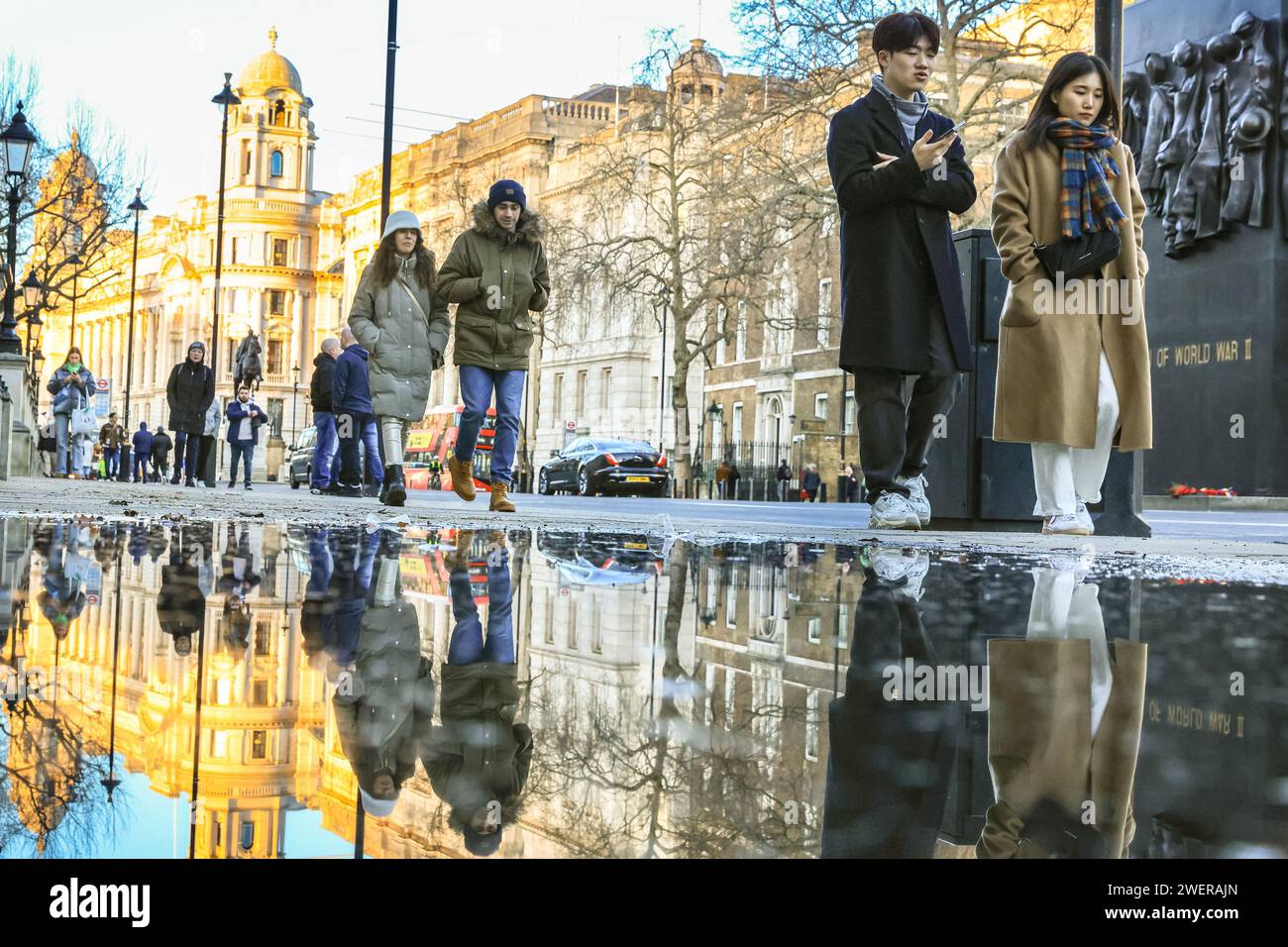 Londres, Royaume-Uni. 26 janvier 2024. Les piétons sur Whitehall se reflètent dans une grande flaque d'eau de pluie de la nuit dernière. Après de fortes averses de pluie pendant la nuit, la capitale a vu le soleil et le ciel clair jusqu'au soir aujourd'hui. Crédit : Imageplotter/Alamy Live News Banque D'Images