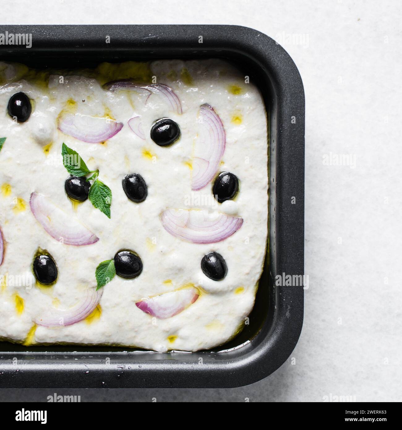 Vue de dessus de focaccia aux olives et aux oignons sur fond blanc, plat de focaccia avec olives noires et garniture à l'oignon rouge, pain focaccia frais maison Banque D'Images