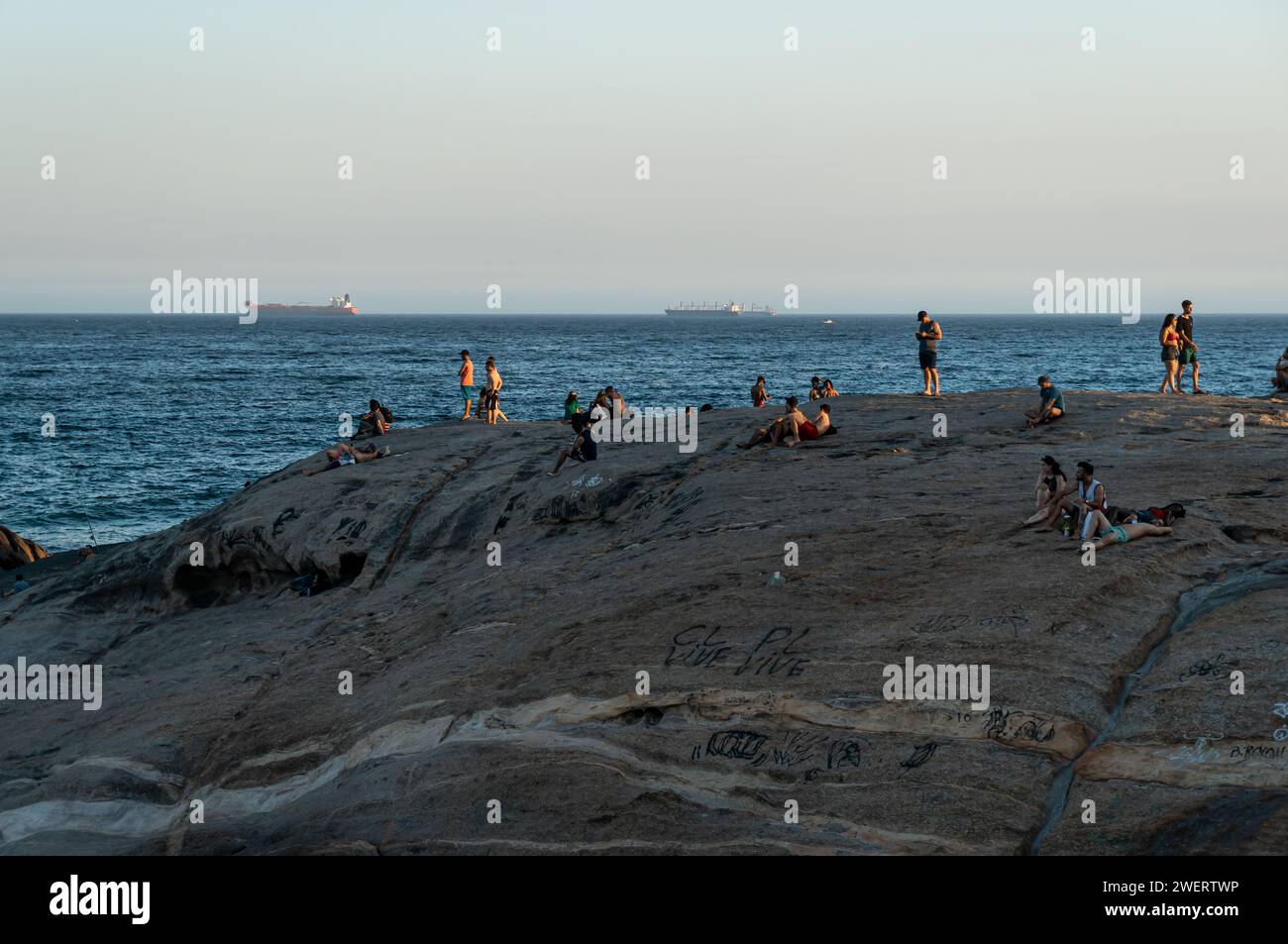 Les gens apprécient les environs sur la péninsule rocheuse de Pedra do Arpoador entre les districts d'Ipanema et Copacabana sous l'après-midi d'été ciel bleu clair. Banque D'Images