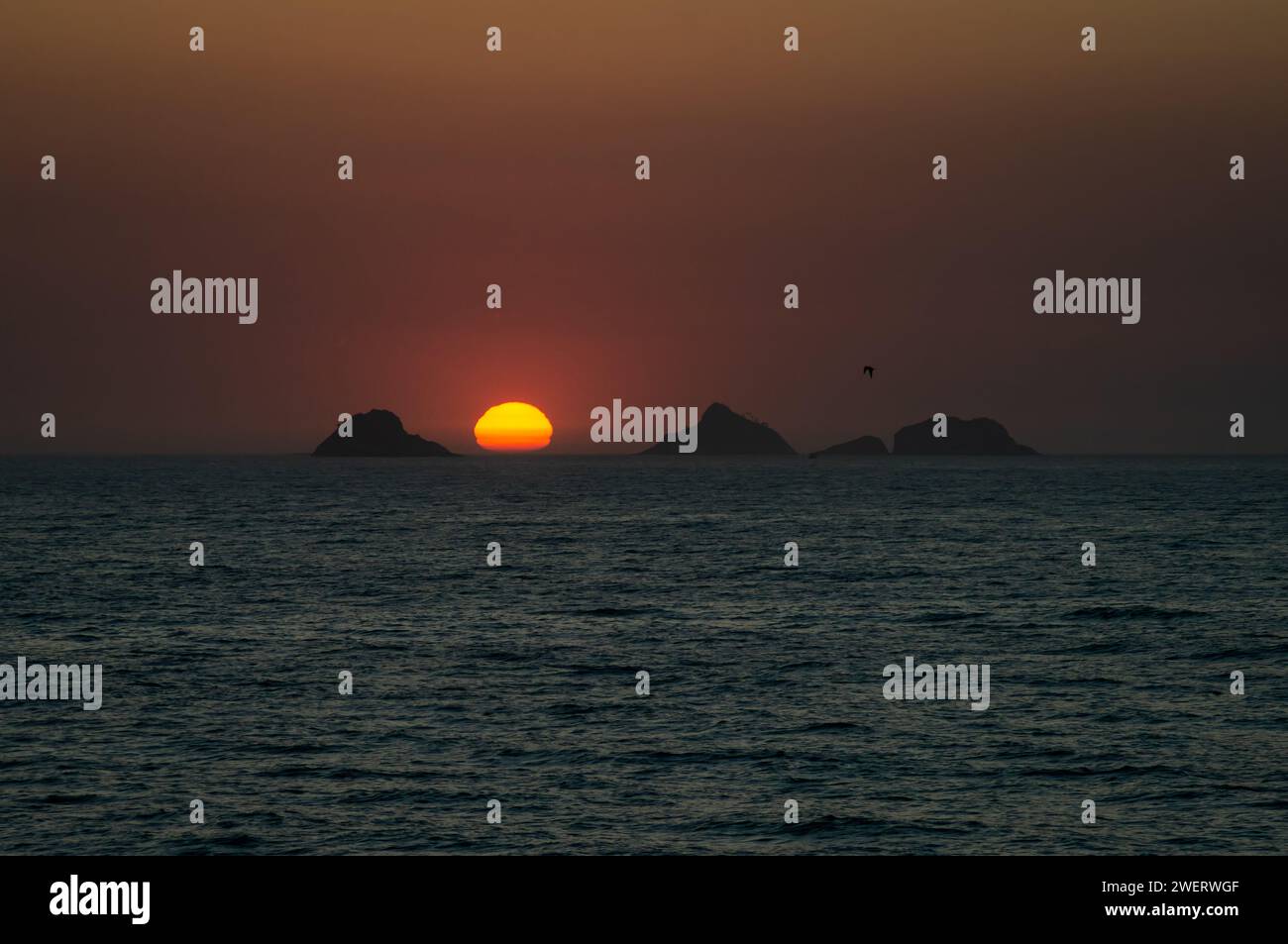 Coucher de soleil crépuscule vue sur le ciel comme vu depuis le rocher Arpoador (Pedra do Arpoador) avec les îles Tijucas en vue à l'horizon sous le ciel ensoleillé de l'après-midi d'été. Banque D'Images