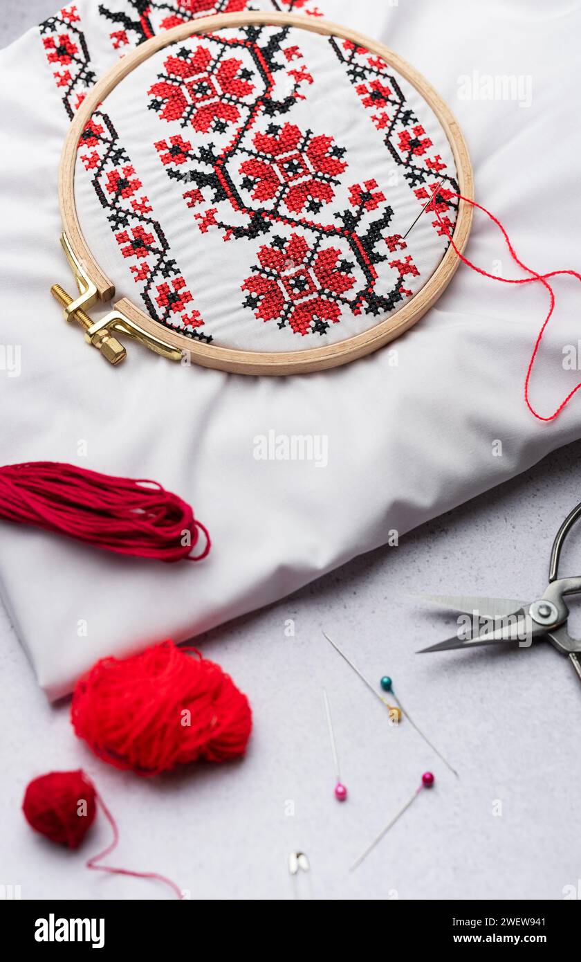 Broderie avec des fils colorés et divers accessoires de couture sur la table Banque D'Images