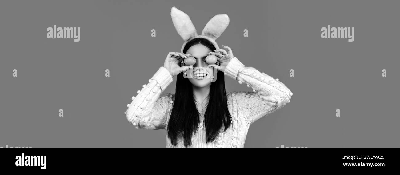 Bannière Pâques.Femme drôle portant des oreilles de lapin et s'amusant avec des œufs de Pâques.Jouer à la chasse aux œufs.Concept joyeuses Pâques. Banque D'Images