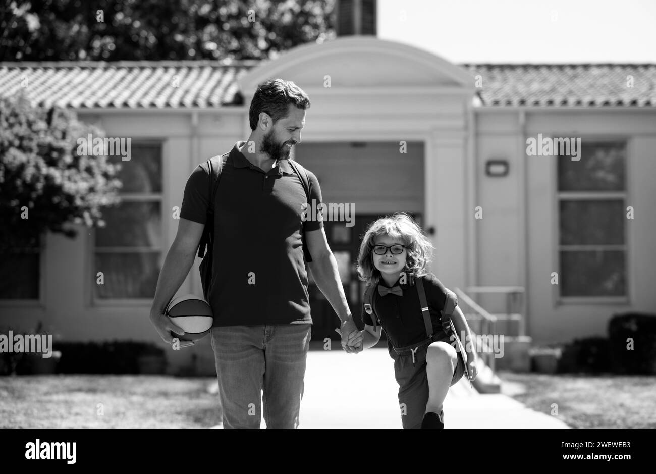 Père et fils marchant dans le parc scolaire. Début des leçons. Banque D'Images