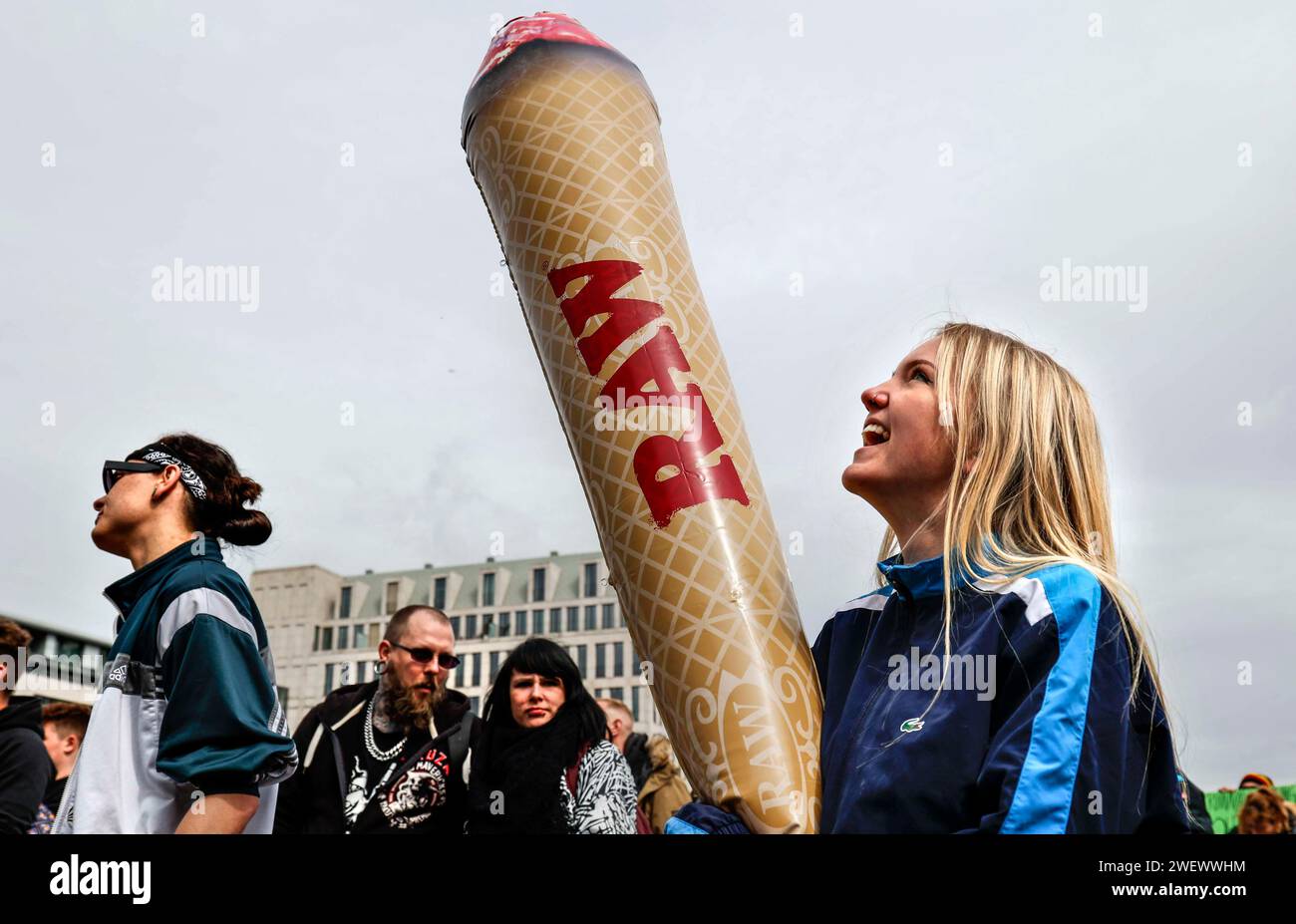 Une femme tient le modèle d'un joint géant lors d'une manifestation en faveur de la consommation légale de marijuana. Les manifestants appellent à la légalisation et Banque D'Images