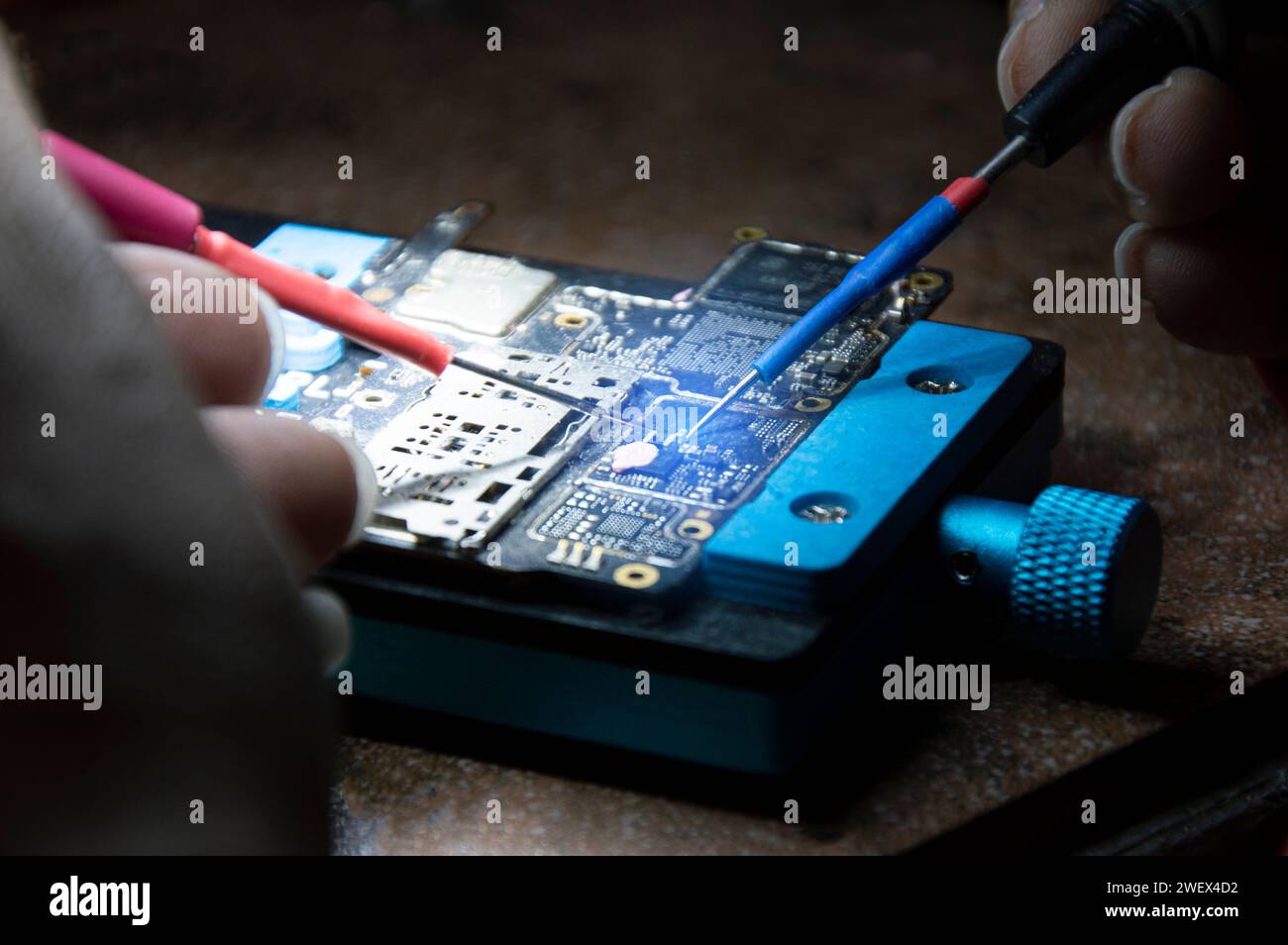 Vue latérale du mécanicien effectuant des réparations carte mère smartphone, réparation smartphone, réparation circuit Banque D'Images