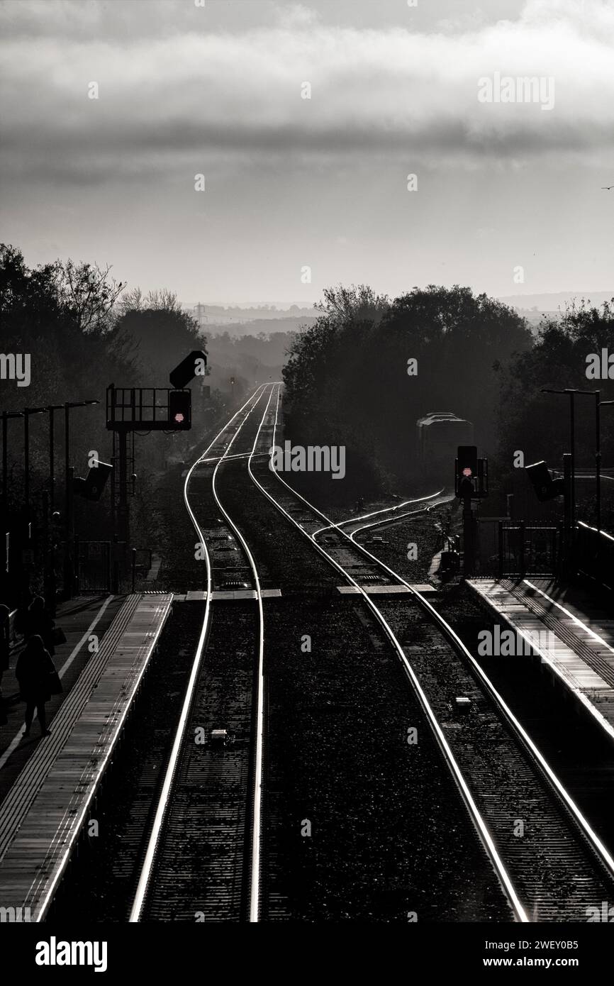 Lumière d'hiver tôt le matin à la gare de Bicester North sur la ligne principale Chiltern avec ligne de chemin de fer et signaux lumineux de couleur. Banque D'Images