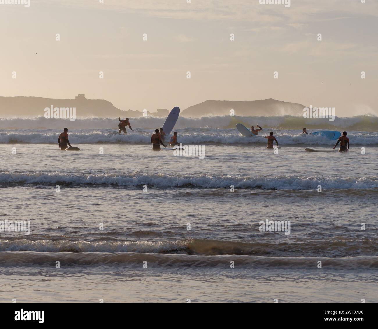 Groupe de surfeurs novices apprenants au coucher du soleil à Essaouira, Maroc, le 27 janvier 2024 Banque D'Images