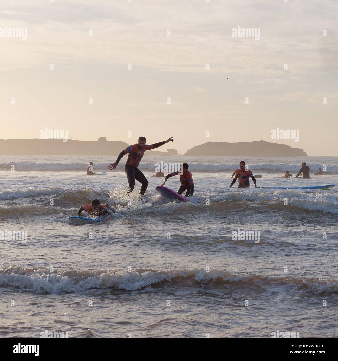 Groupe de surfeurs novices apprenants au coucher du soleil à Essaouira, Maroc, le 27 janvier 2024 Banque D'Images