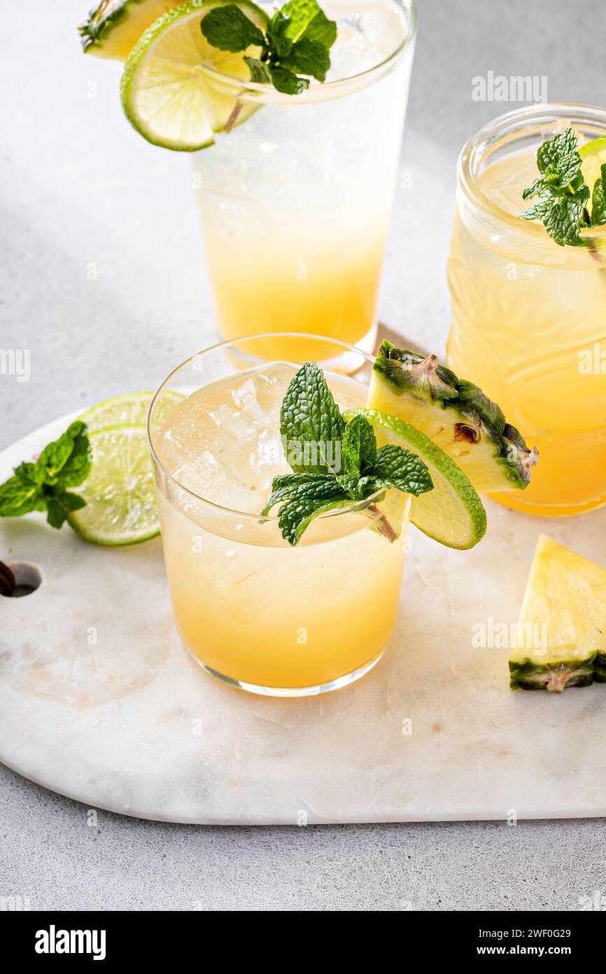 Cocktail de jus d'ananas au citron vert garni d'une tranche d'ananas et de feuille de menthe Banque D'Images