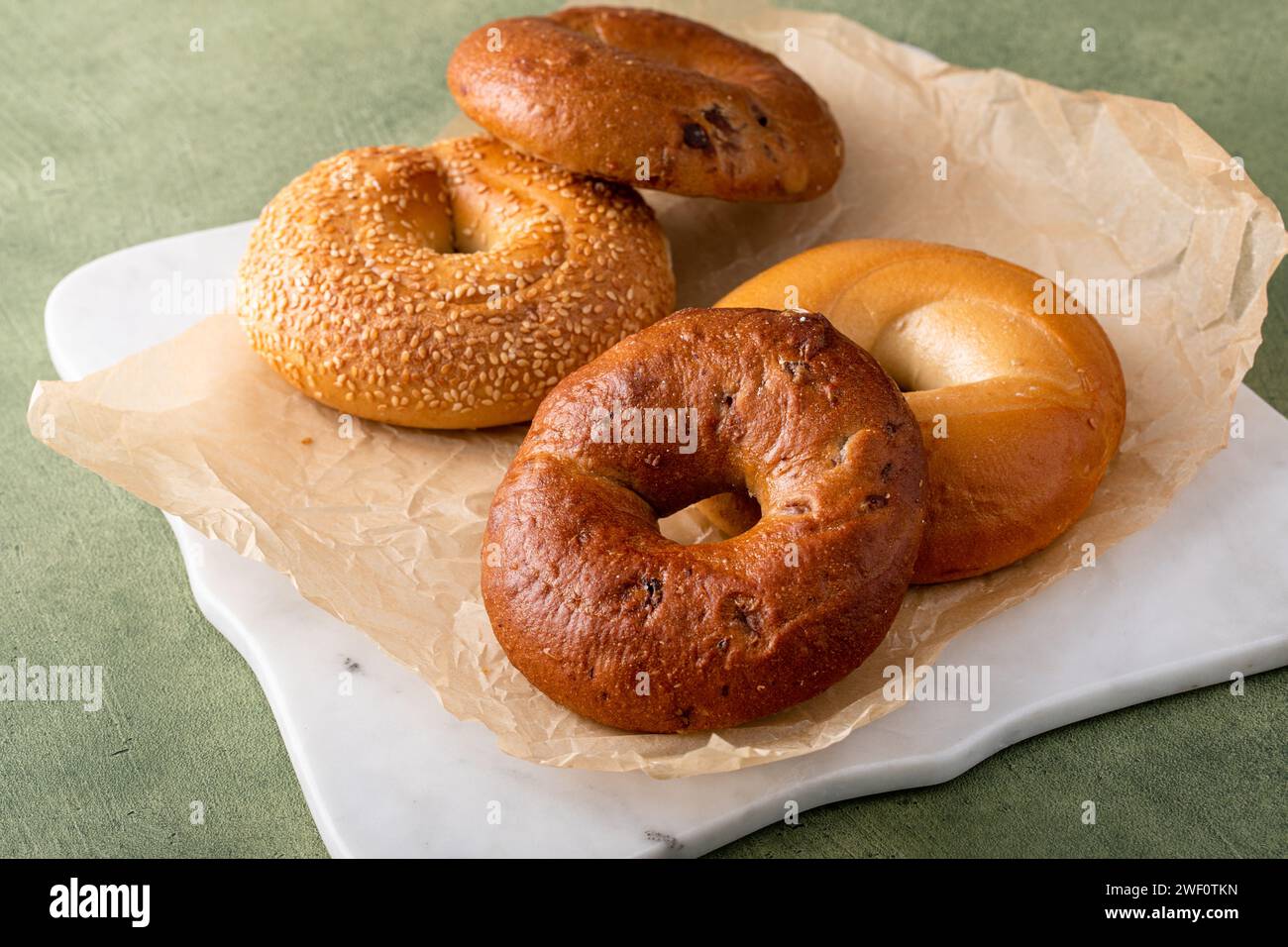 Variété de bagels fraîchement cuits pour le petit déjeuner prêt à manger, nature, graines de sésame et bagels cannelle et raisins secs Banque D'Images