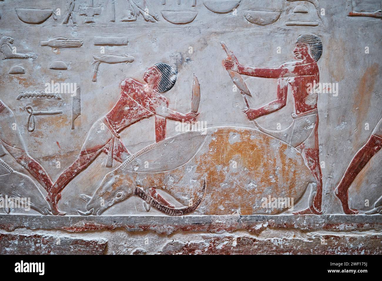 Saqqara, Égypte - 2 janvier 2024 : personnages en bas relief peints montrant la vie quotidienne dans l'Égypte ancienne à l'intérieur de la tombe de Kagemni dans la nécropole de Saqqara Banque D'Images