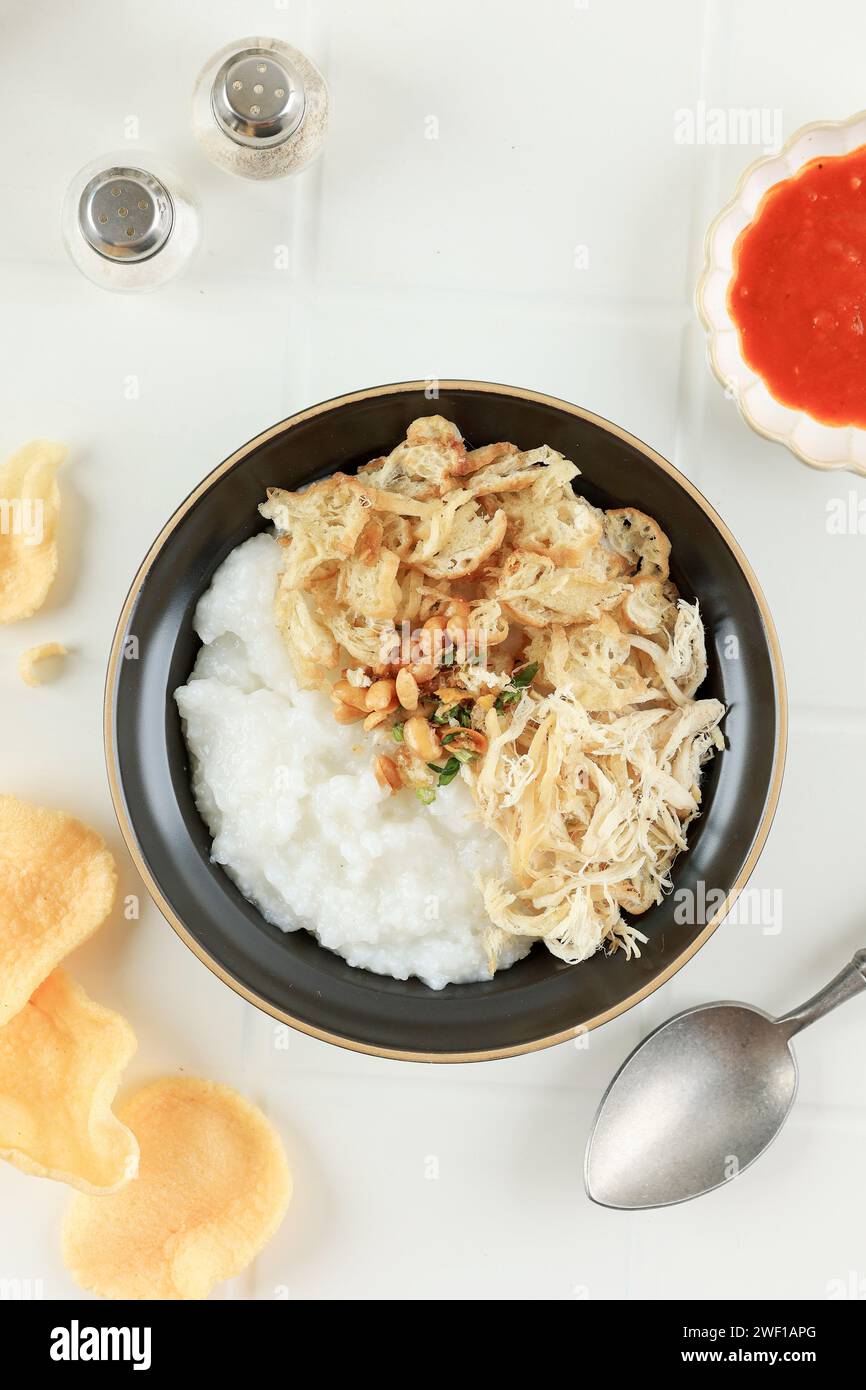 Bubur Ayam ou bouillie de poulet, la nourriture traditionnelle indonésienne se compose de bouillie de riz blanc, poulet râpé, cakwe, soja frit et vert Banque D'Images