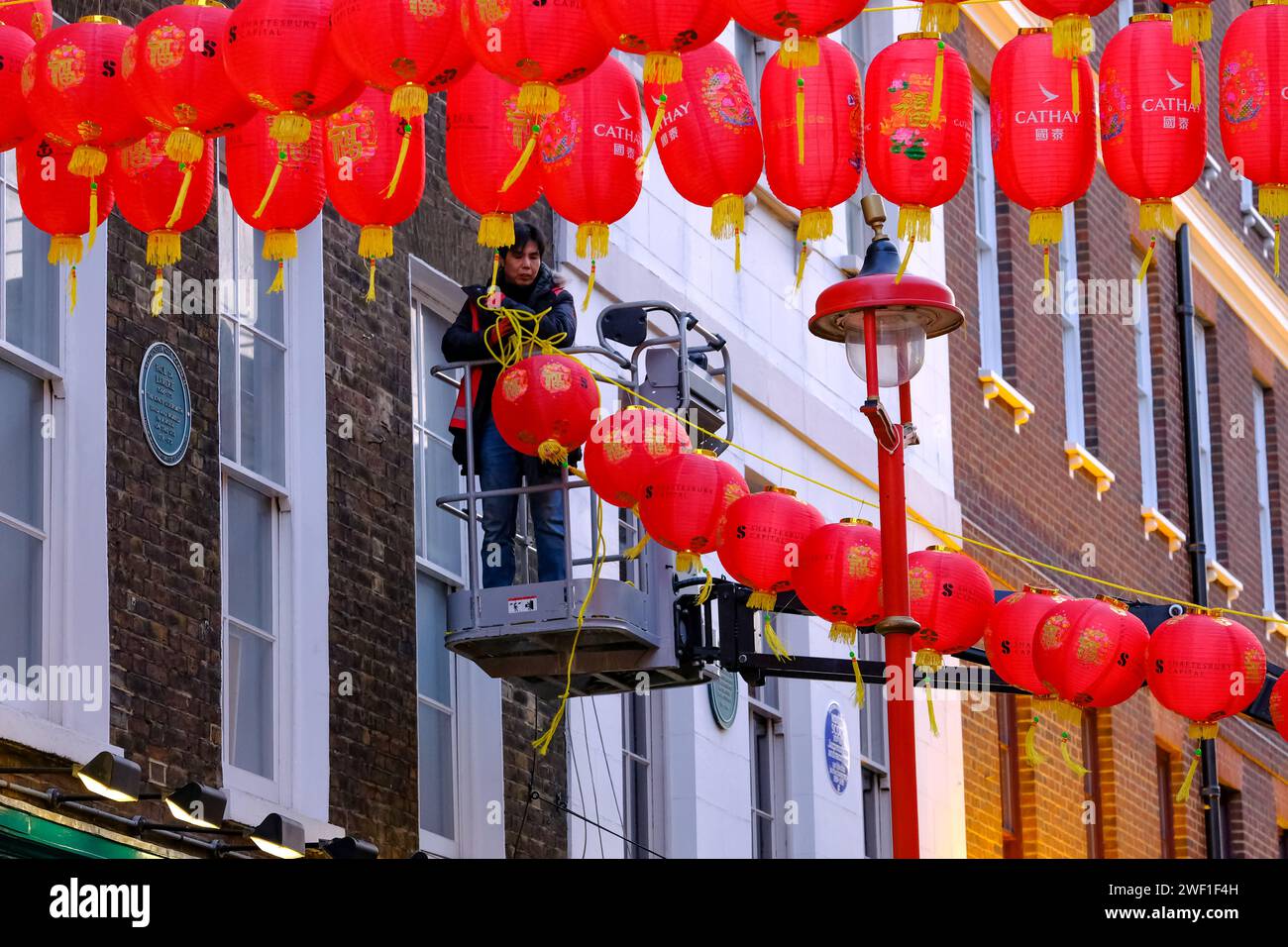 Londres, Royaume-Uni. 27 janvier 2024. Les travailleurs continuent d’installer de nouvelles lanternes rouges vibrantes en préparation du nouvel an lunaire le 10 février, au-dessus des rues de Chinatown. Crédit : Photographie de onzième heure / Alamy Live News Banque D'Images