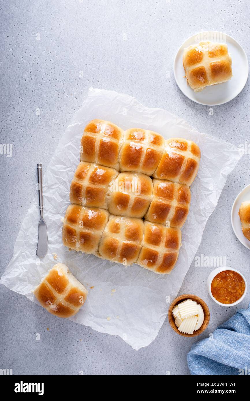 Brioches croisées chaudes servies avec du beurre et de la marmelade d'orange, recette pour le brunch de Pâques ou le petit déjeuner Banque D'Images