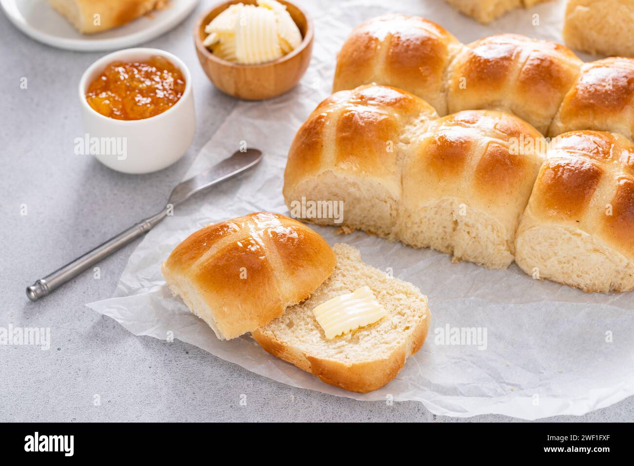 Brioches croisées chaudes servies avec du beurre et de la marmelade d'orange, recette pour le brunch de Pâques ou le petit déjeuner Banque D'Images
